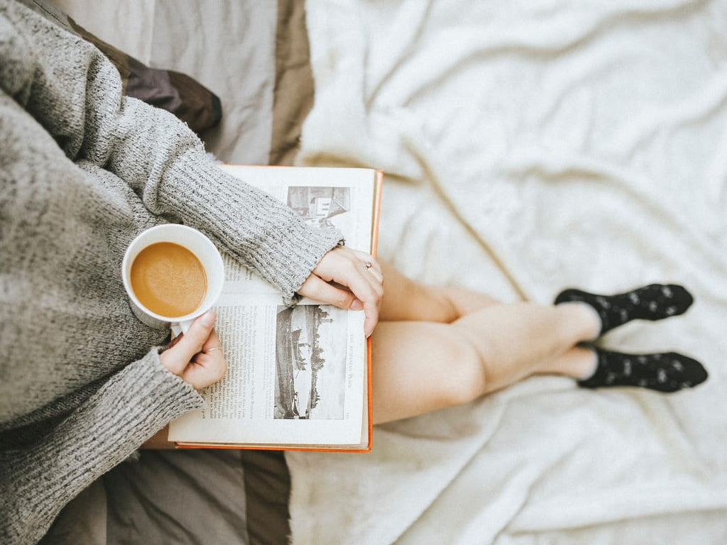 Woman enjoying a book and coffee.